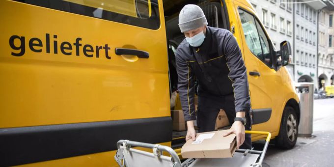 Ein Paketbote der Post stapelt während der Auslieferung die Pakete auf einen Wagen, am Donnerstag, 11. Februar 2021, in Bern. Post Pakete