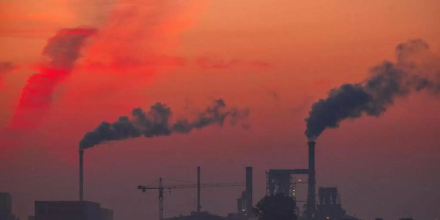 Aufsteigender Rauch aus Fabrikschornsteinen: Bis zum Jahr 2040 soll bereits ein Rückgang des klimaschädlichen Ausstosses um 88 Prozent erreicht sein. Foto: Jens Büttner/dpa-Zentralbild/dpa