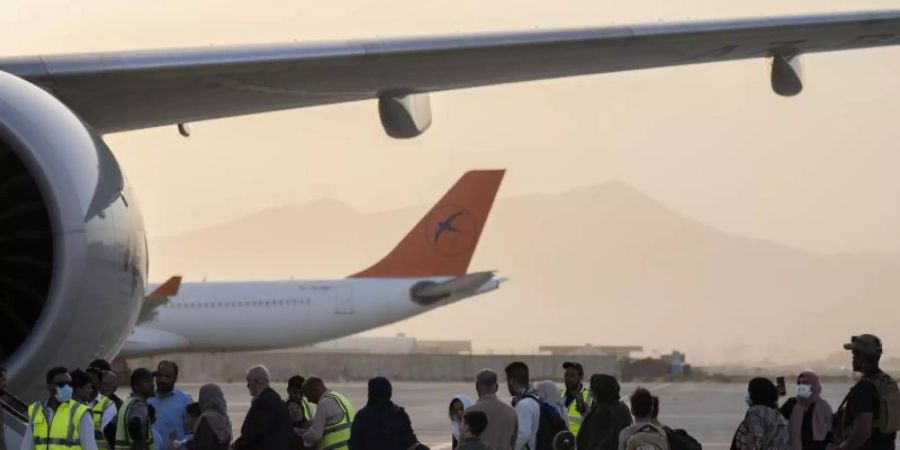 Doppelstaatler, deren Ausreise erlaubt wurde, besteigen in Kabul ein Flugzeug der Fluggesellschaft Qatar Airways. Foto: Bernat Armangue/AP/dpa