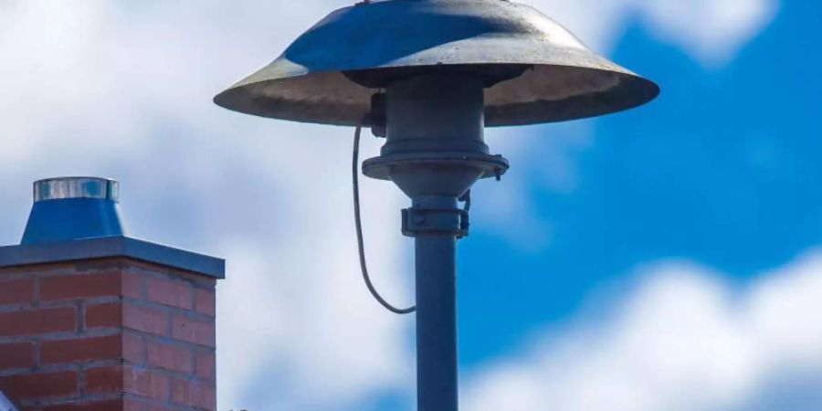 Eine Alarmsirene auf einem Hausdach. Foto: Jens Büttner/dpa-Zentralbild/dpa