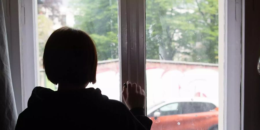 ARCHIV - ILLUSTRATION - Eine Jugendliche blickt aus einem Fenster. Die Pandemie hat bei Kindern und Jugendlichen in England deutliche Spuren bei der psychischen Gesundheit hinterlassen. Foto: Paul Zinken/dpa