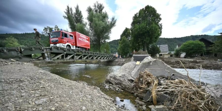 Ein Feuerwehrauto überquert eine Notbrücke der Bundeswehr