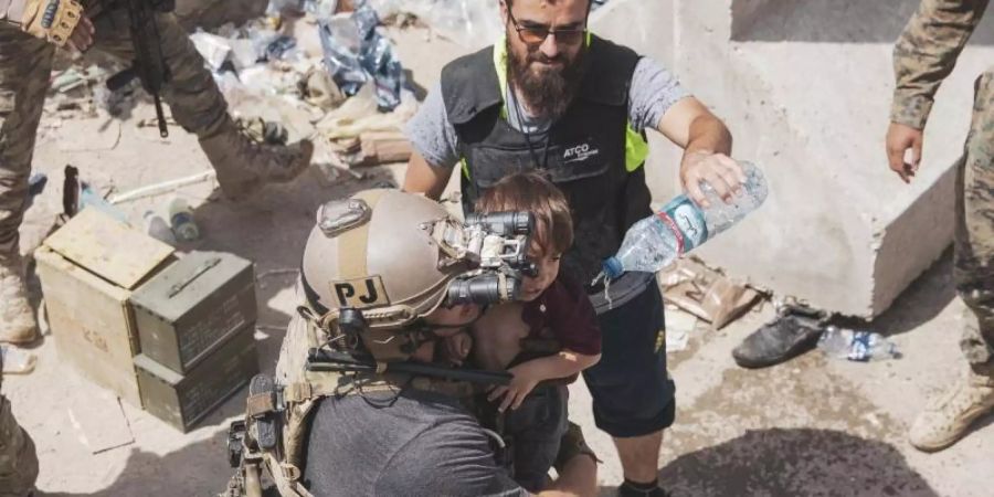 Auf diesem vom US Marine Corps zur Verfügung gestellten Foto trägt ein US-Soldat ein Kind an einem Evakuierungskontrollpunkt am Kabuler Flughafen. Foto: Staff Sgt. Victor Mancilla/U.S. Marine Corps/AP/dpa