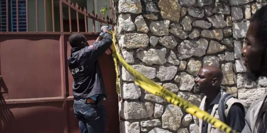 Ein Mitglied der Sicherheitskräfte versperrt den Zugang zu der Residenz des haitianischen Präsidenten Moïse. Foto: Joseph Odelyn/AP/dpa