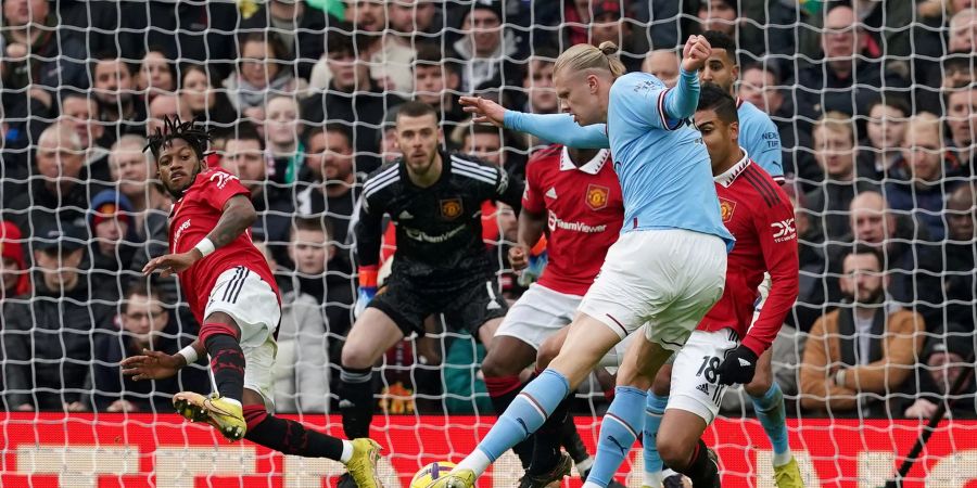 Fred von Manchester United (l) wirft sich in den Schuss von City-Stürmer Erling Haaland (vorne).