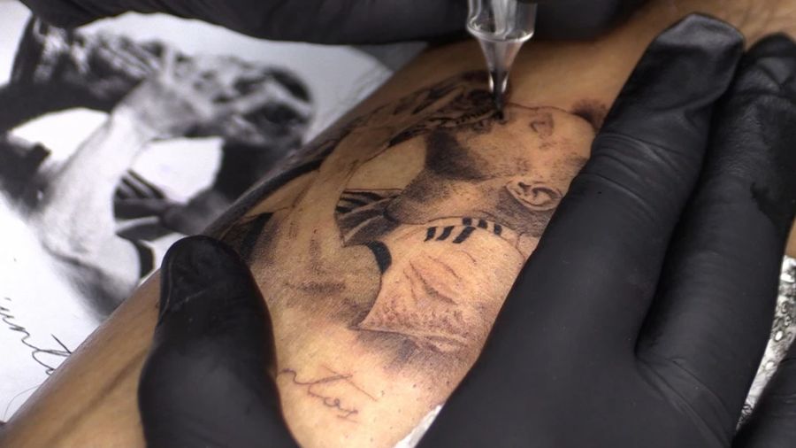 Eine Person in Rosario lässt sich ein Tattoo von Lionel Messi stechen, auf dem er den WM-Pokal küsst. Nach Argentiniens Gewinn der WM 2022 ist die Nachfrage nach Messi-Tattoos stark gestiege