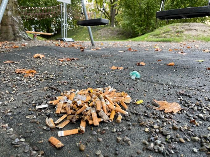 Ein Haufen Zigarettenstummel auf einem Spielplatz. stop2drop