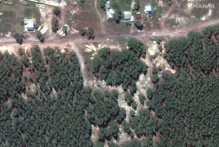 Dieses von Maxar Technologies bereitgestellte Satellitenbild zeigt den Eingang zu Massengräbern im Wald.