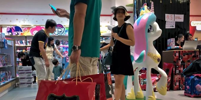 Ein Mann trägt eine Einkaufstasche mit Spielzeug, das er in einem neu eröffneten Laden des amerikanischen Spielwaren-Unternehmens FAO Schwarz in einem beliebten Einkaufszentrum in Peking gekauft hat. Handelsstreit China-USA