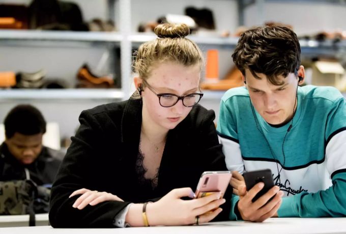 Soziales Netzwerk Instagram: Zwei Jugendliche checken ihre Likes. Insbesondere Minderjährige stehen durch die Gefällt-mir-Angaben unter sozialem Druck. soziales Netzwerk