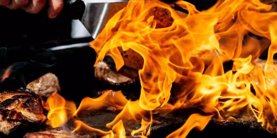 Auf einem Feuergrill wird der Nacken vom Iberico-Schwein gegrillt. Foto: Swen Pförtner/Illustration