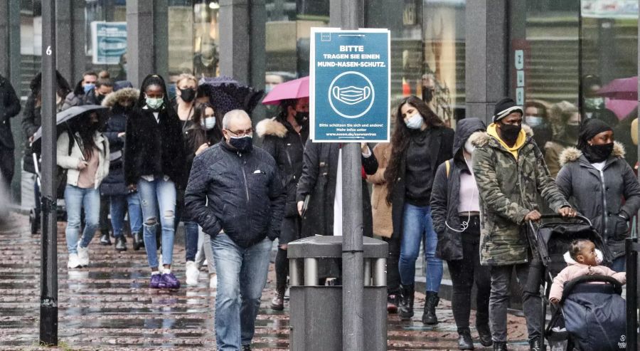 Menschen warten bei Kälte und Regen im Stadtzentrum von Essen.