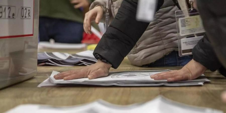 Mitarbeiter der Wahlkommission zählen die abgegebenen Stimmen nach Schliessung der Wahllokale. Foto: Visar Kryeziu/AP/dpa