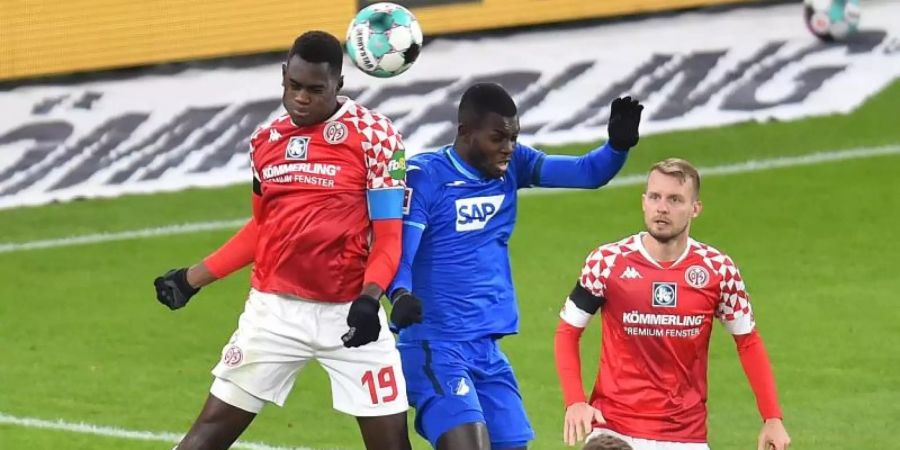 Der Mainzer Moussa Niakhate (l) im Kopfballduell mit Hoffenheims Ihlas Bebou. Foto: Torsten Silz/dpa