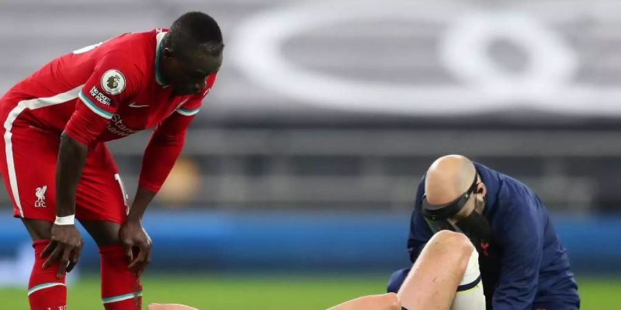 Harry Kane (M) musste in der ersten Halbzeit mehrmals behandelt werden und wurde in der Halbzeitpause ausgewechselt. Foto: Catherine Ivill/POOL GETTY/PA Wire/dpa