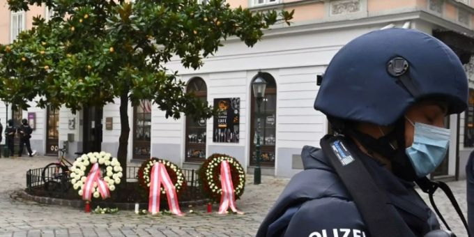 Ein Polizist vor Blumenkränzen Ein Polizist vor Blumenkränzen