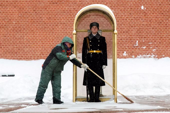 Ein städtischer Arbeiter räumt Schnee vor einem Soldaten der Ehrengarde, der auf seinem Posten am Grabmal des Unbekannten Soldaten steht. Die wöchentliche Temperatur in Moskau liegt tagsüber bei etwa -12 Grad Celsius und fällt nachts auf -18 Grad. Winterwetter in Russland