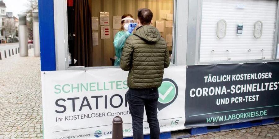 Eine Mitarbeiterin einer Teststation in der Oldenburger Innenstadt nimmt einen Abstrich von einem jungen Mann. (Archivbild). Foto: Hauke-Christian Dittrich/dpa