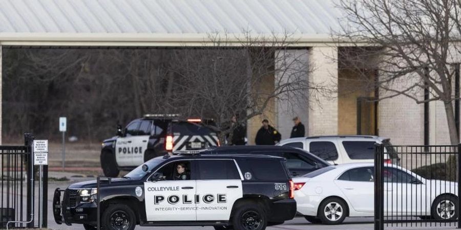 Polizeifahrzeuge stehen während der Geiselnahme auf der Zufahrt der Synagoge in Colleyville. Foto: Brandon Wade/AP/dpa