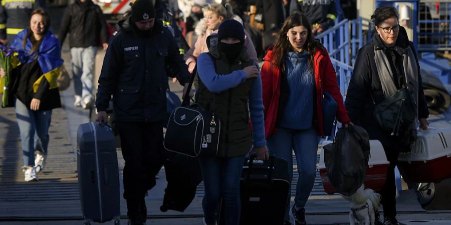 Kriegsflüchtlinge aus der Ukraine verlassen die Fähre mit ihrem Gepäck. Foto: Andreea Alexandru/AP/dpa