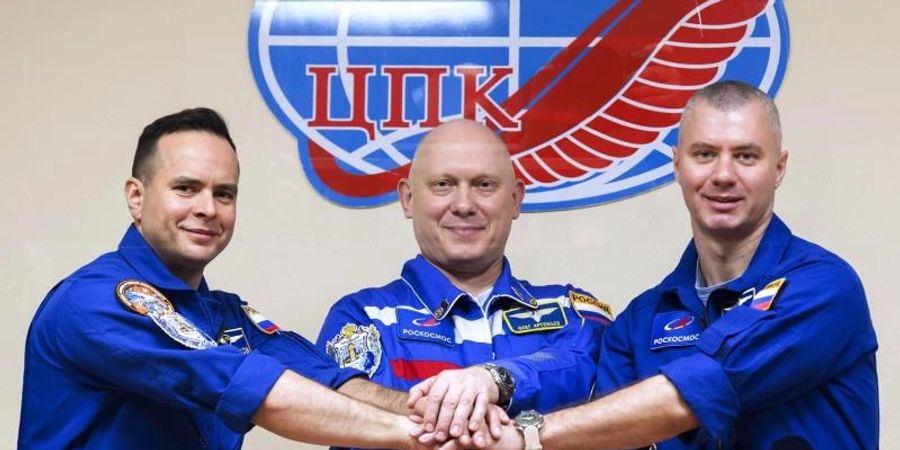 Die russischen Kosmonauten, Kommandant Oleg Artemjew (M) und die Flugingenieure Denis Matwejew (r) und Sergej Korssakow posieren für die Presse. Foto: Irina Spektor/Roscosmos Space Agency/AP/dpa