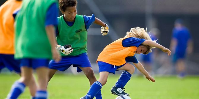 Kinder spielen Fussball.