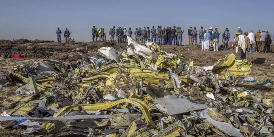 Überreste des Flugzeugwracks der Ethiopian Airlines werden am Absturzort gesammelt. Die Fluggesellschaft hat alle Maschinen vom Typ Boeing 737 Max 8 vorläufig aus dem Verkehr gezogen. Foto: Mulugeta Ayene/AP