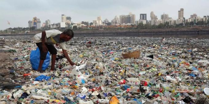 Ein Mann sammelt Plastik an der von Müll übersäten Küste des Arabisches Meeres in Mumbai. Meeresmüll