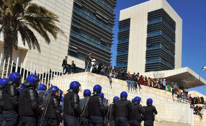 Polizisten beobachten Demonstranten bei einem Protest gegen die Kandidatur des algerischen Ex-Präsidenten Bouteflika, der für eine fünfte Amtszeit kandidieren wollte Protest gegen Algeriens Präsident