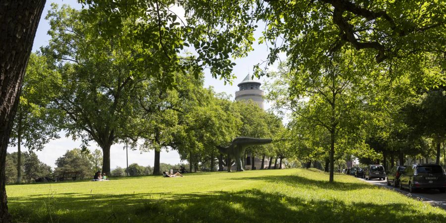 Die Grünanlage mit Dinosaurierplastik und der historische Wasserturm im vornehmen Bruderholzquartier in Basel.