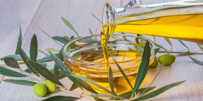 Olivenöl wird in eine Schale gegossen.