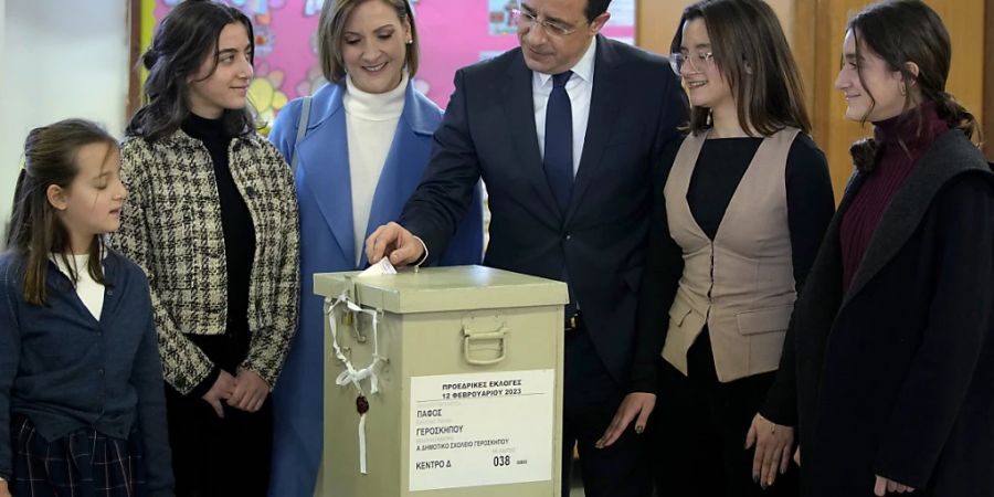 Präsidentschaftskandidat Nikos Christodoulides (M) gibt seine Stimme während der zypriotischen Präsidentschaftswahlen ab. Foto: Petros Karadjias/AP/dpa