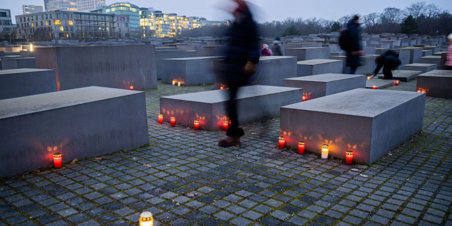 Kerzen brennen am Vorabend des Internationalen Tags des Gedenkens an die Opfer des Holocaust zwischen den Stelen des Denkmals für die ermordeten Juden Europas in Berlin.