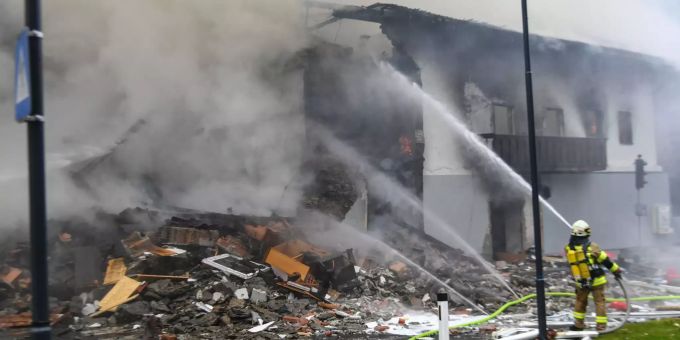 Ein Feuerwehrmann löscht einen Brand in einem Gebäude. Bei einer Explosion in einem Gebäude in Tirol sind nach ersten Erkenntnissen neun Menschen verletzt worden. Tirol