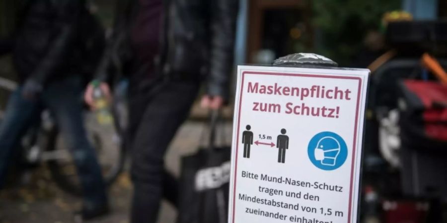 Schild weist auf Maskenpflicht hin