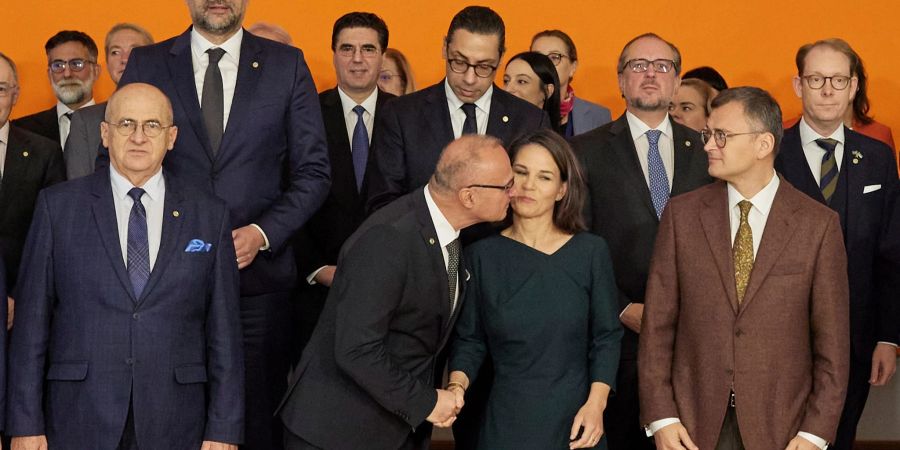 Der kroatische Aussenminister Gordan Grlić Radman begrüsst Annalena Baerbock mit einen Kuss beim Gruppenbild im Rahmen der Europakonferenz in Berlin.