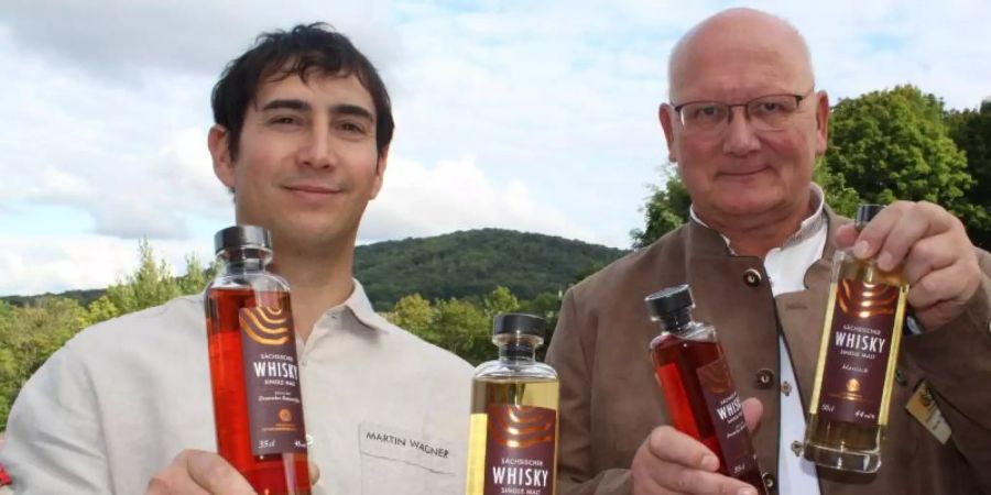 Brenner und Start-up-Unternehmer Martin Wagner und Brauereichef Steffen Dittmer aus Löbau mit dem ersten Oberlausitzer Whisky. Foto: Miriam Schönbach/dpa-Zentralbild/dpa