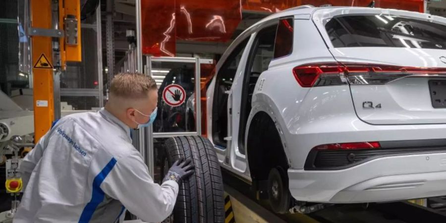 Ein Mitarbeiter im Volkswagen-Werk in Zwickau montiert einen Audi Q4 e-tron. Foto: Hendrik Schmidt/dpa-Zentralbild/dpa