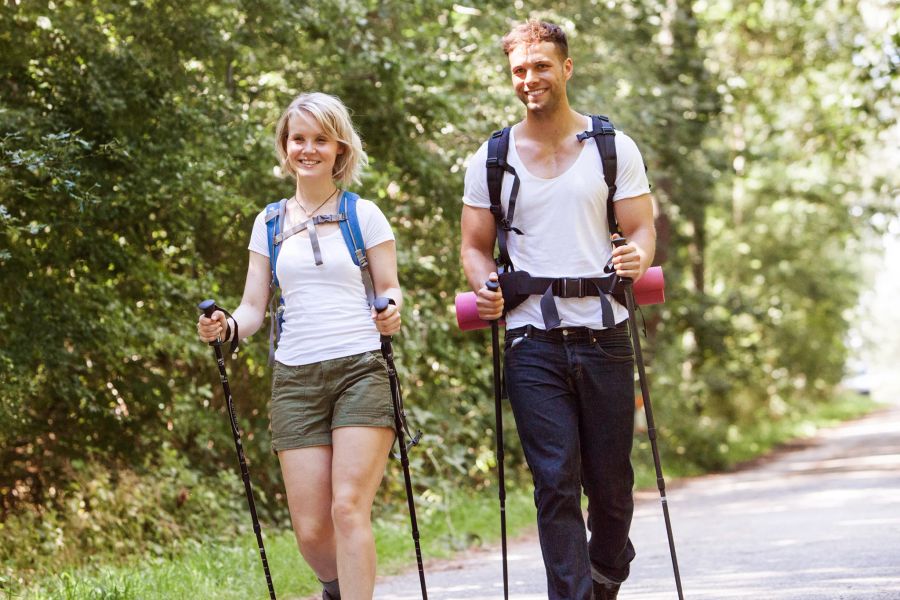 Frau Mann Wandern Trekkingstöcke Strasse