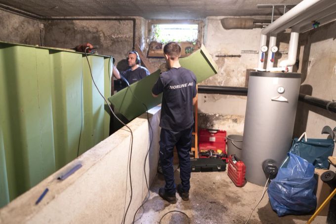 Zwei Heizungsinstallateure demontieren einen Öltank im Keller eines Hauses. Die Ölheizung wird durch eine Erdwärmpumpe mit Erdsonde ersetzt. (Archivbild) nebenkosten