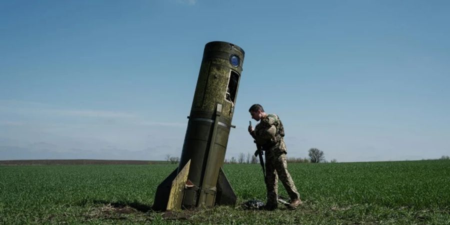 Ein Soldat neben Raketentrümmern in der Ukraine.