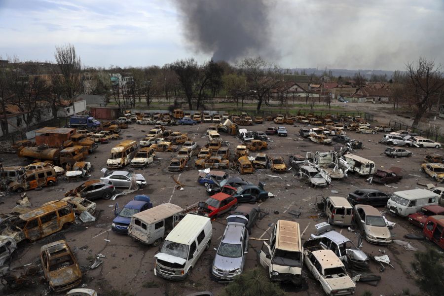 Beschädigte und verbrannte Fahrzeuge sind in Mariupol zu sehen.