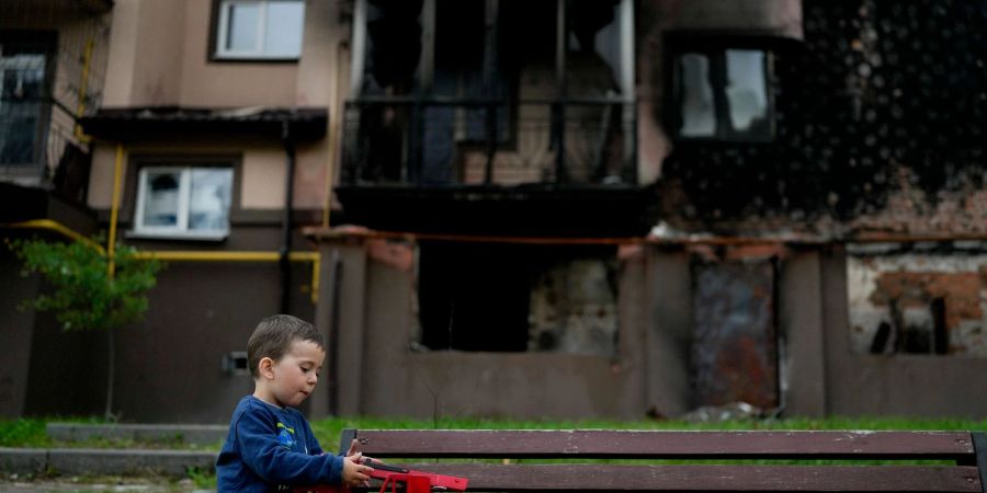 Vor einem zerstörten Gebäude in Irpin nahe Kiew spielt der kleine Yarik mit seinem Spielzeug-Lastwagen. (Archiv)