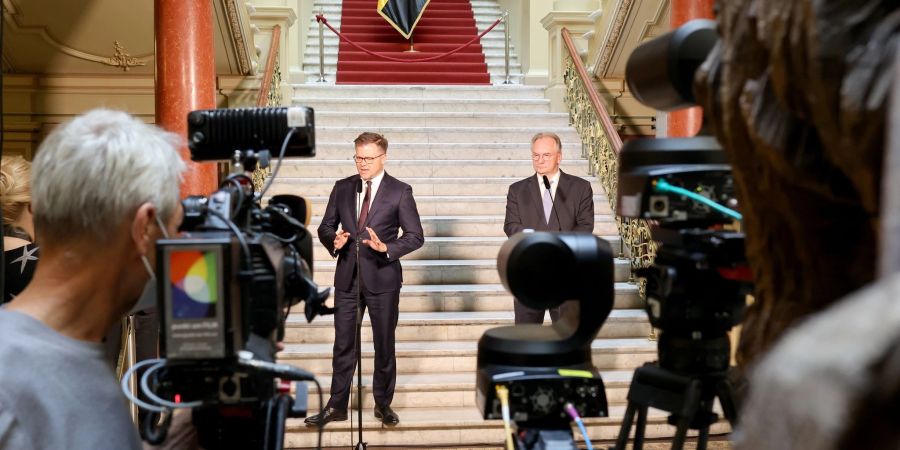 Der Ostbeauftragte Carsten Schneider (SPD, l) und Sachsen-Anhalts Ministerpräsident Reiner Haseloff (CDU) treten gemeinsam vor die Presse.