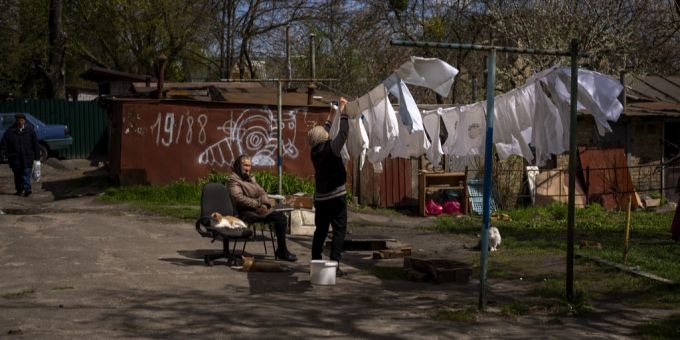 Normalität kehrt trotz Ukraine-Kriegs ein. Eine Frau in Butscha hängt ihre Wäsche auf. Ukraine Krieg Butscha