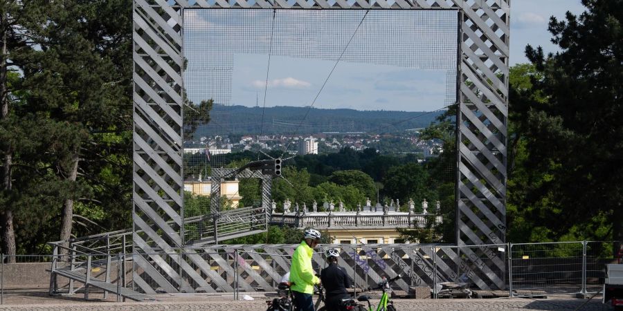 Radfahrer vor dem mit Bauzaun eingerüsteten Rahmenbau von Haus-Rucker-Co von der documenta 6.