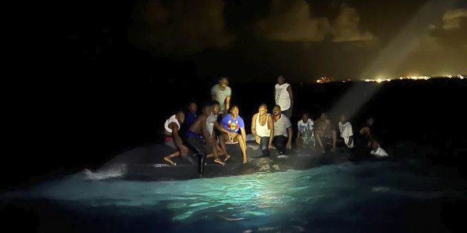 Überlebende sitzen auf einen gekentertem Boot vor den Bahamas und warten auf Rettung. bahamas