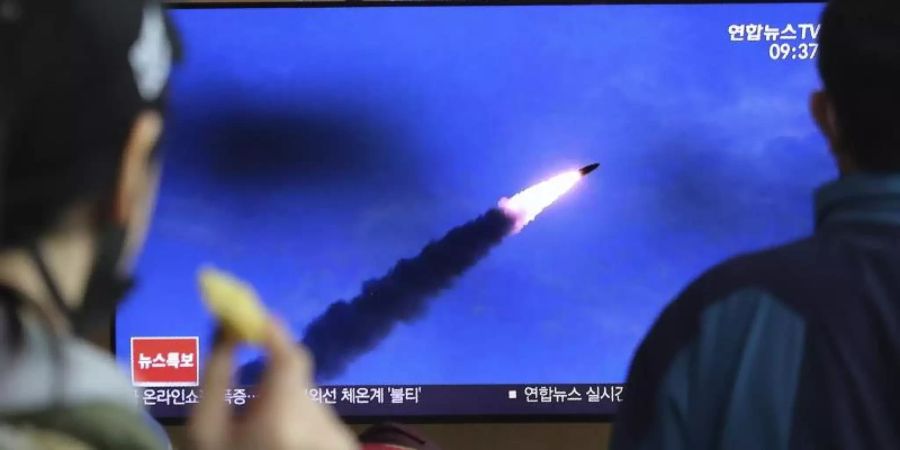 Menschen im Bahnhof von Seoul verfolgen eine Nachrichtensendung, in der über den Abschuss der Raketen berichtet wird. Foto: Ahn Young-Joon/AP/dpa