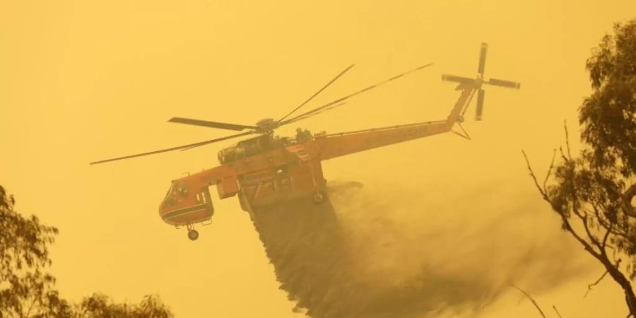 Die Buschbrände in Australien wüten weiter. Ein Hubschrauber wirft Löschwasser auf ein Feuer in der Nähe von Bumbalong, südlich der Hauptstadt Canberra, ab. Foto: Rick Rycroft/AP/dpa