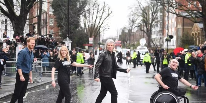 Jon Bon Jovi und Prinz Harry mit Mitgliedern des Invictus-Games-Chors auf dem berühmten Zebrastreifen vor den Abbey Road Studios. Foto: Victoria Jones/PA Wire/dpa Abbey Road